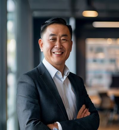 张伟，大屁股视频传媒创始人CEO，身着商务休闲装在现代办公室内自信微笑，背景为品牌LOGO墙，气质成熟稳重